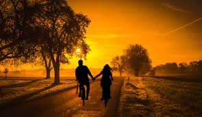 couple-holding-hands-riding-into-sunset