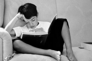 boy-reading-book-on-sofa